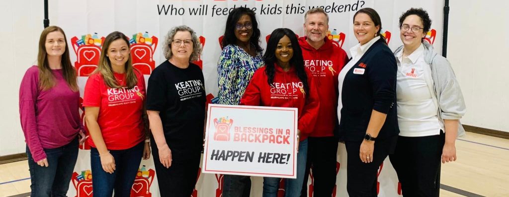 Frederick chapter members holding Blessings in a Backpack sign